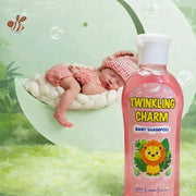 Baby lying on a white cushion next to a bottle of Twinkling Charm baby shampoo with a green background.