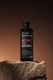 Bottle of Anti-Hair Loss Hair Tonic on a stone surface with a brown background