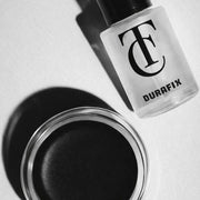 Durafix nail polish bottle and black nail polish jar on a light gray background