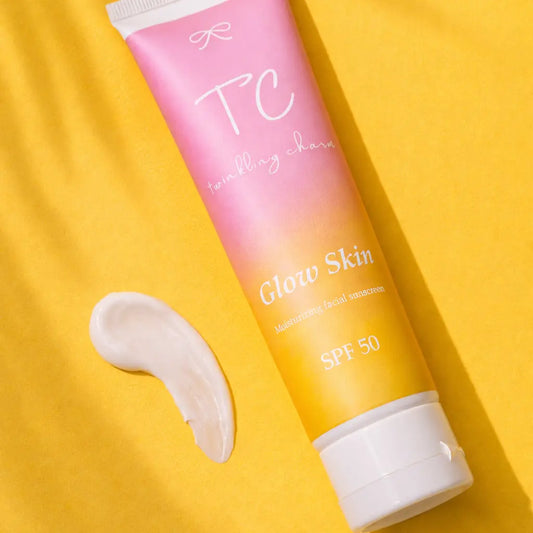Tube of 'TC' Glow Skin sunscreen with a swatch on a yellow background