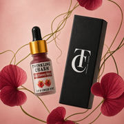 Twinkling Charm lip and cheek tint bottle with packaging on a pink background with flowers.