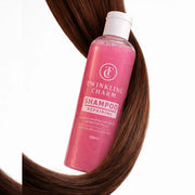 Pink shampoo bottle labeled 'Twinkling Charm' with brown hair in the background