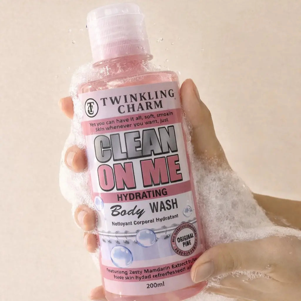 Hand holding a bottle of Twinkling Charm Clean On Me Hydrating Body Wash with bubbles in the background.